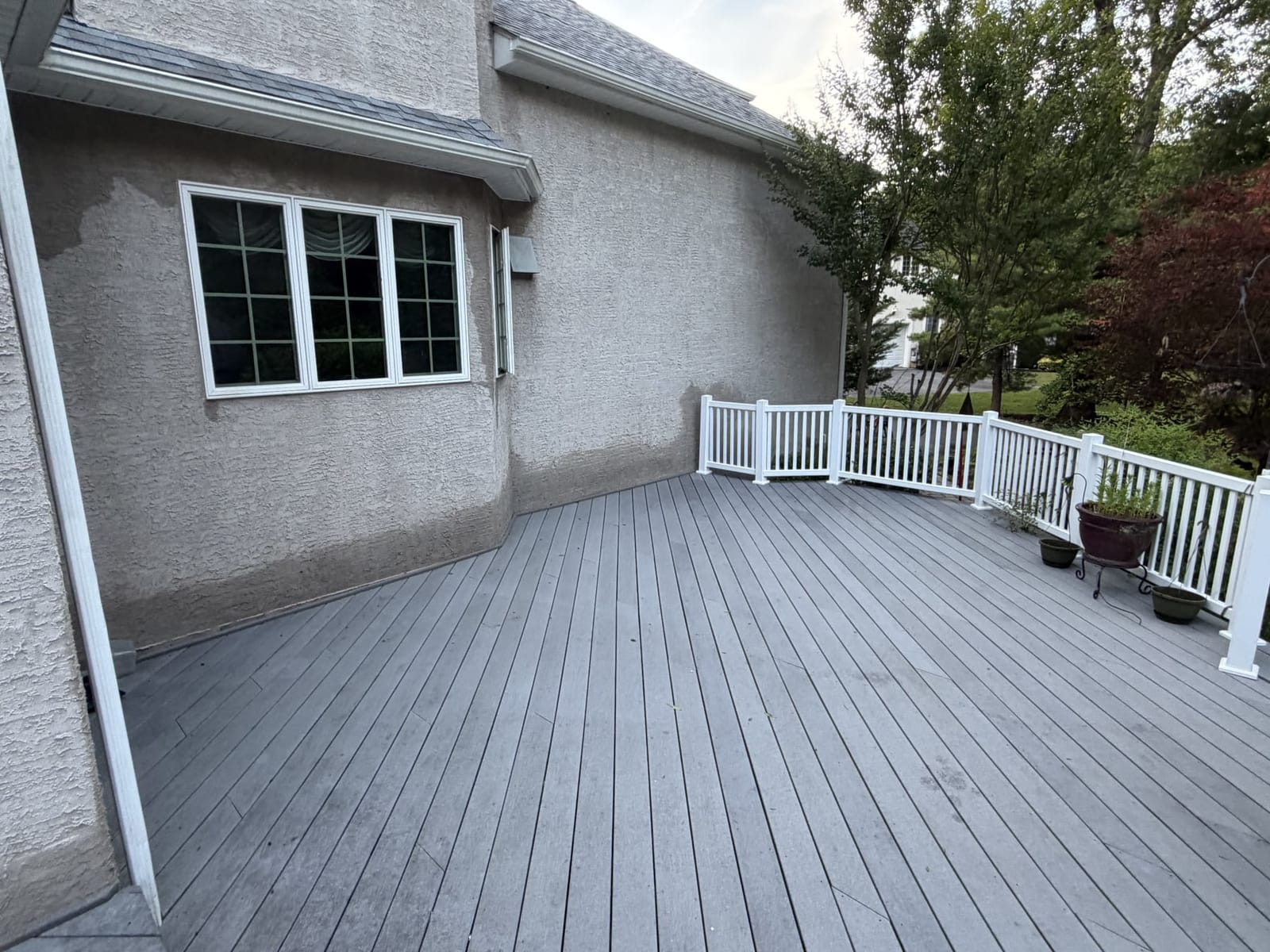 Soft washed house exterior beside a clean deck